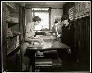 Jonge vrouw die stoffen inpakt voor een thuiswerker om mee te nemen, bij de New York Association for the Blind, 111 East 59th Street, New York, 1931